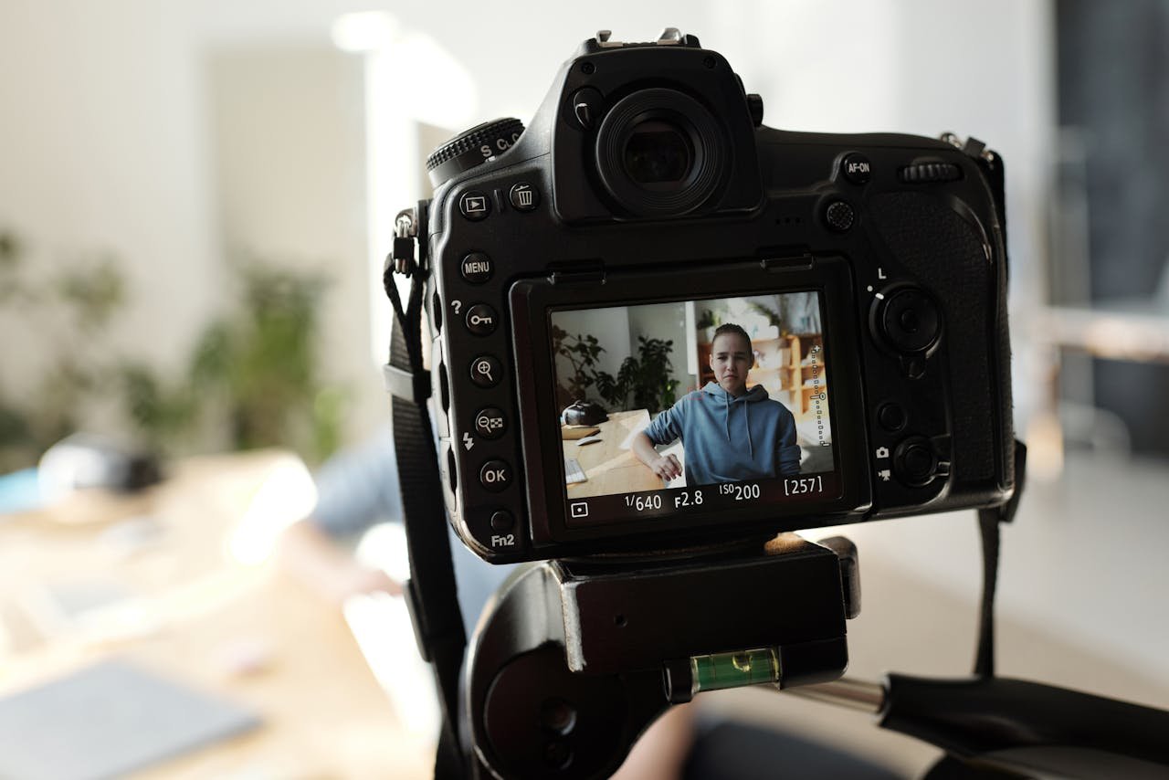 portfolio-img-08 Closeup of DSLR capturing a young adult indoors during daytime. The display shows the portrait in focus.